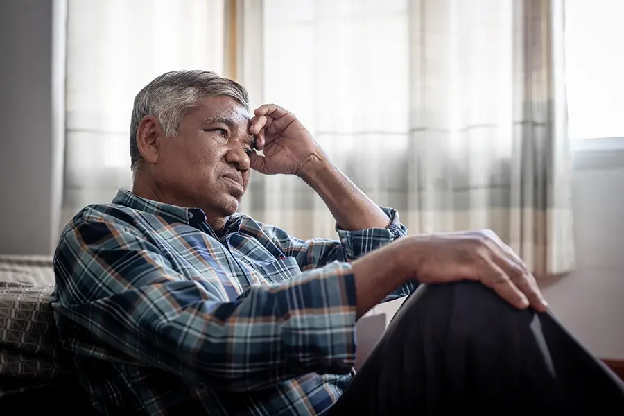 worried senior man sitting alone at home